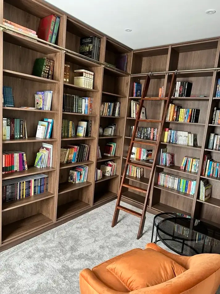 Biblioteka w zabudowie z drewnianą drabiną na mosiężnej prowadnicy