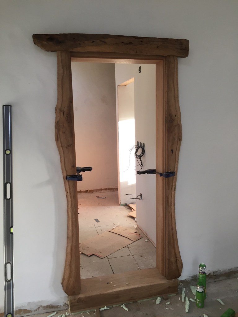 Dębowe drzwi wykonane z kilkusetletniego drewna, wykończone masywnymi architrawami.